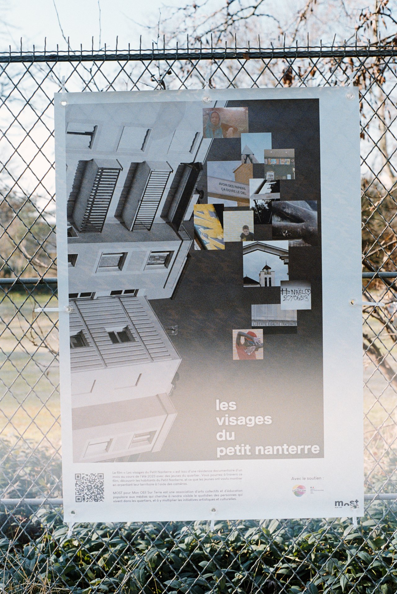 la bâche « les visages du petit nanterre » sur une grille